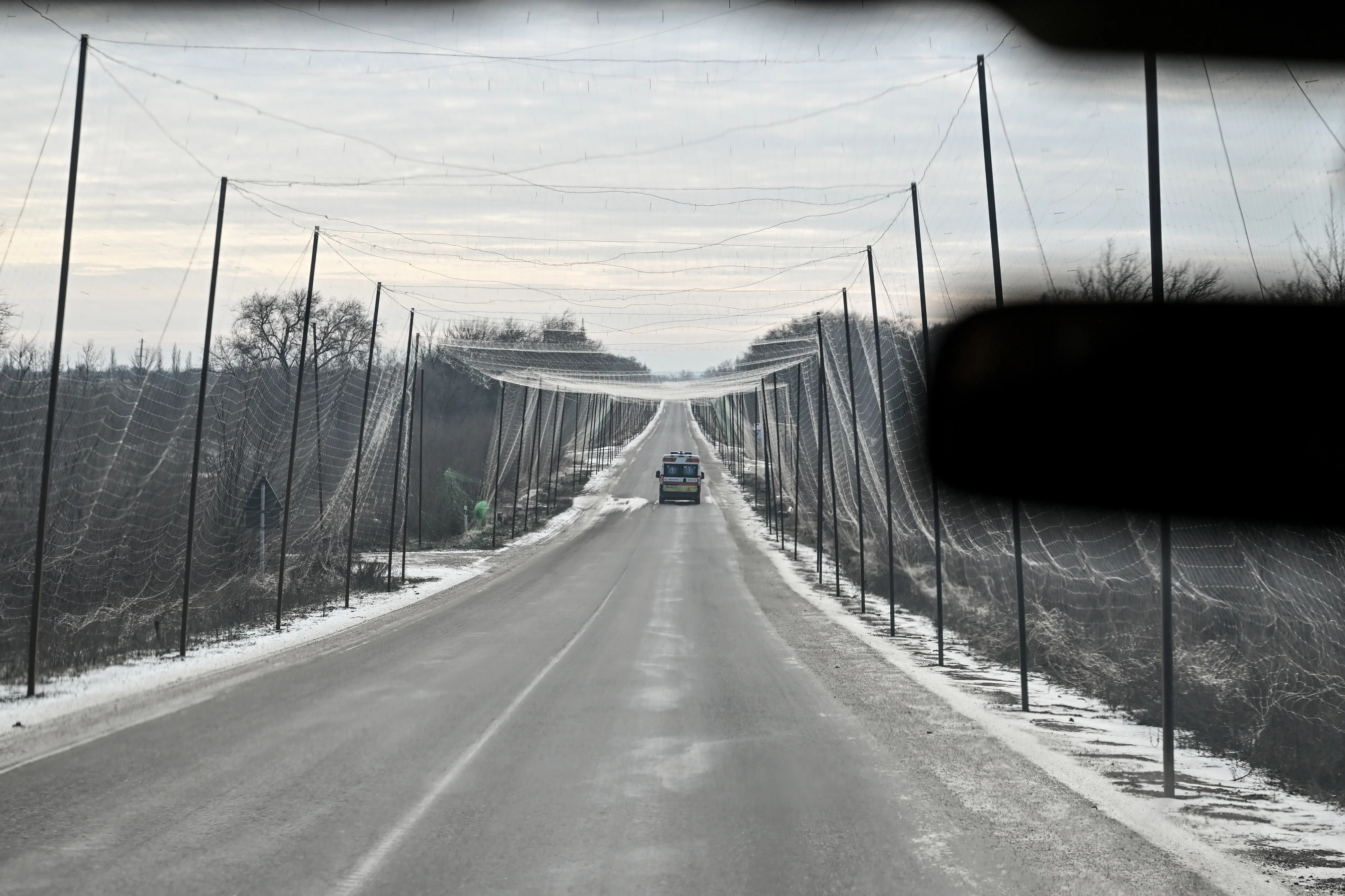 An ambulance evacuates residents from the front-line villages of Tavriiske and Yurkivka and drives along a road shielded by an anti-drone net against Russian FPV drones in the Zaporizhzhia region, Ukraine, on February 3, 2026.