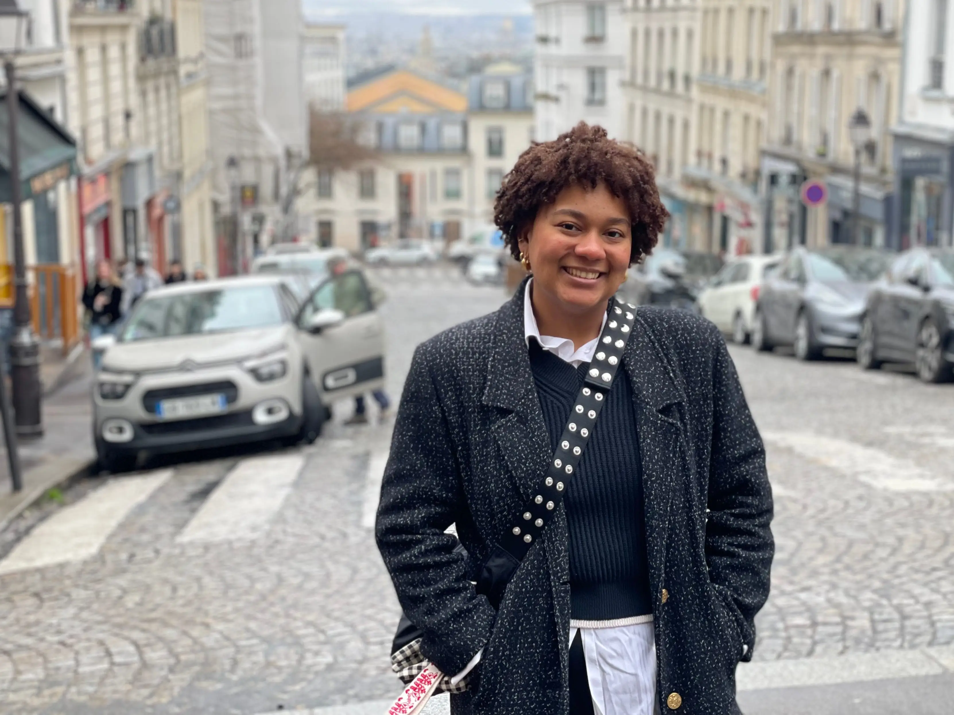 Woman smiling in middle of walkway in Paris