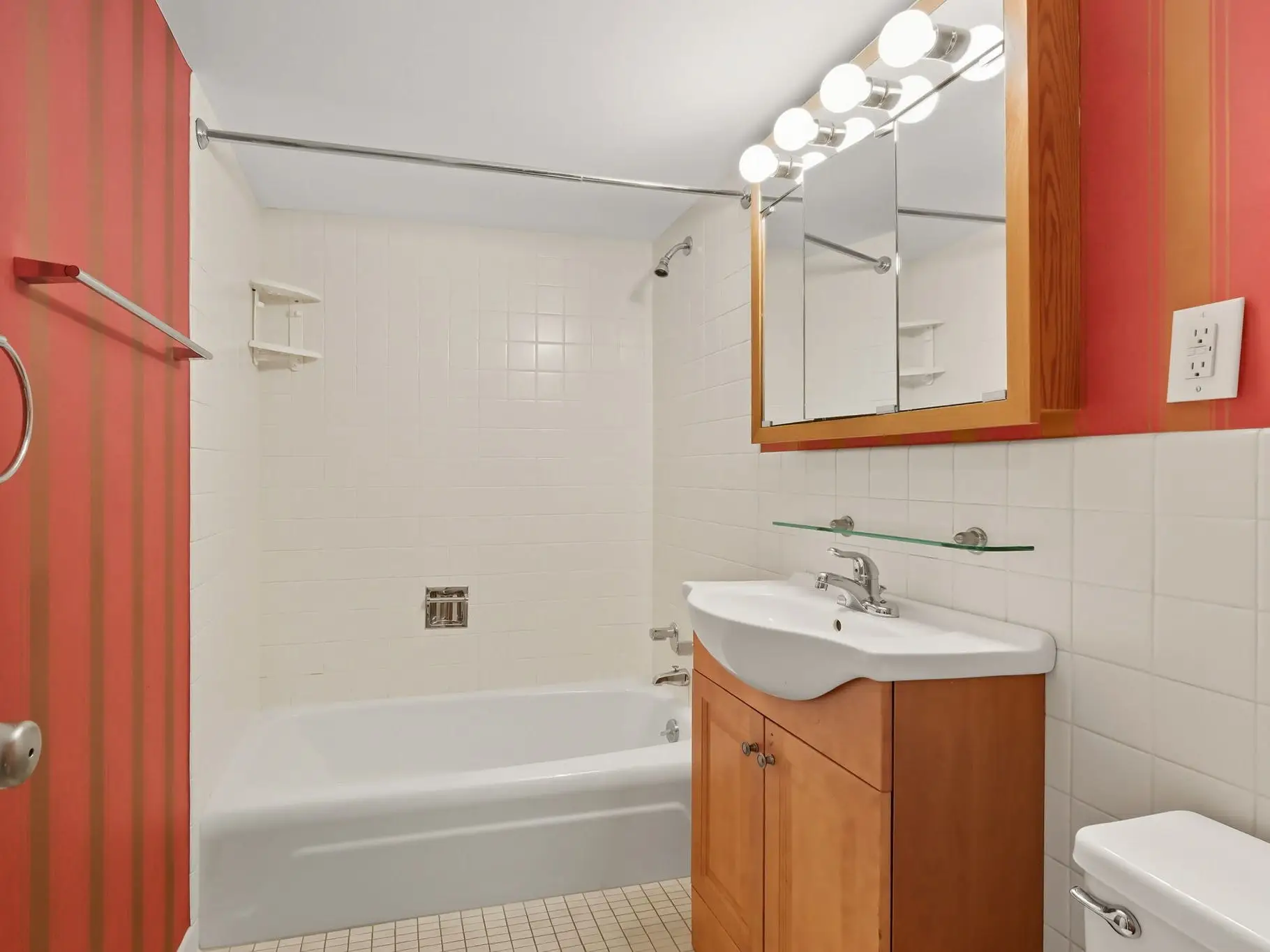 A bathroom with cabinets, a toilet and tub.
