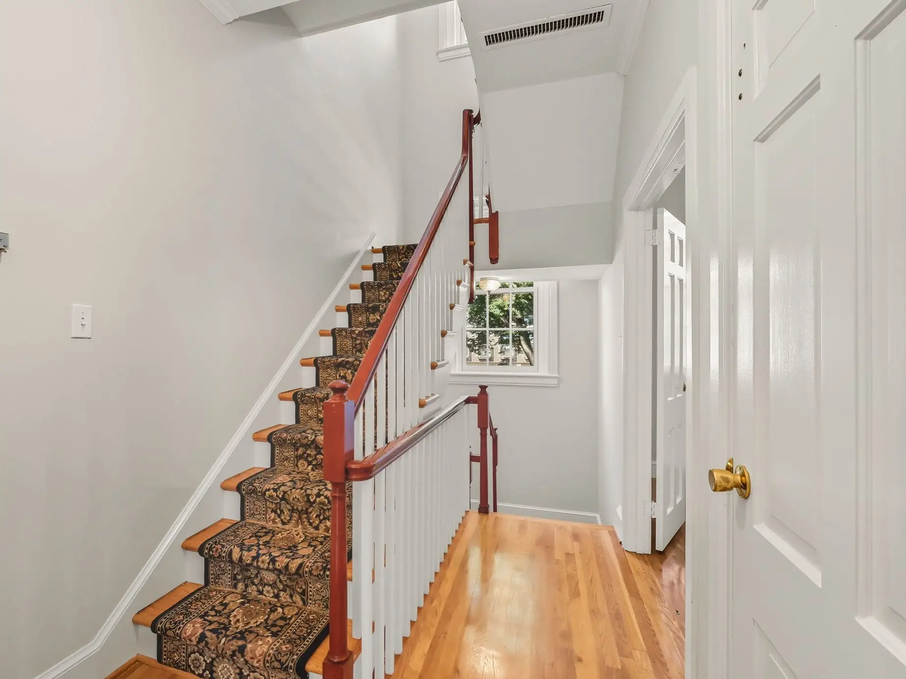 A staircase with an intricately designed carpet.