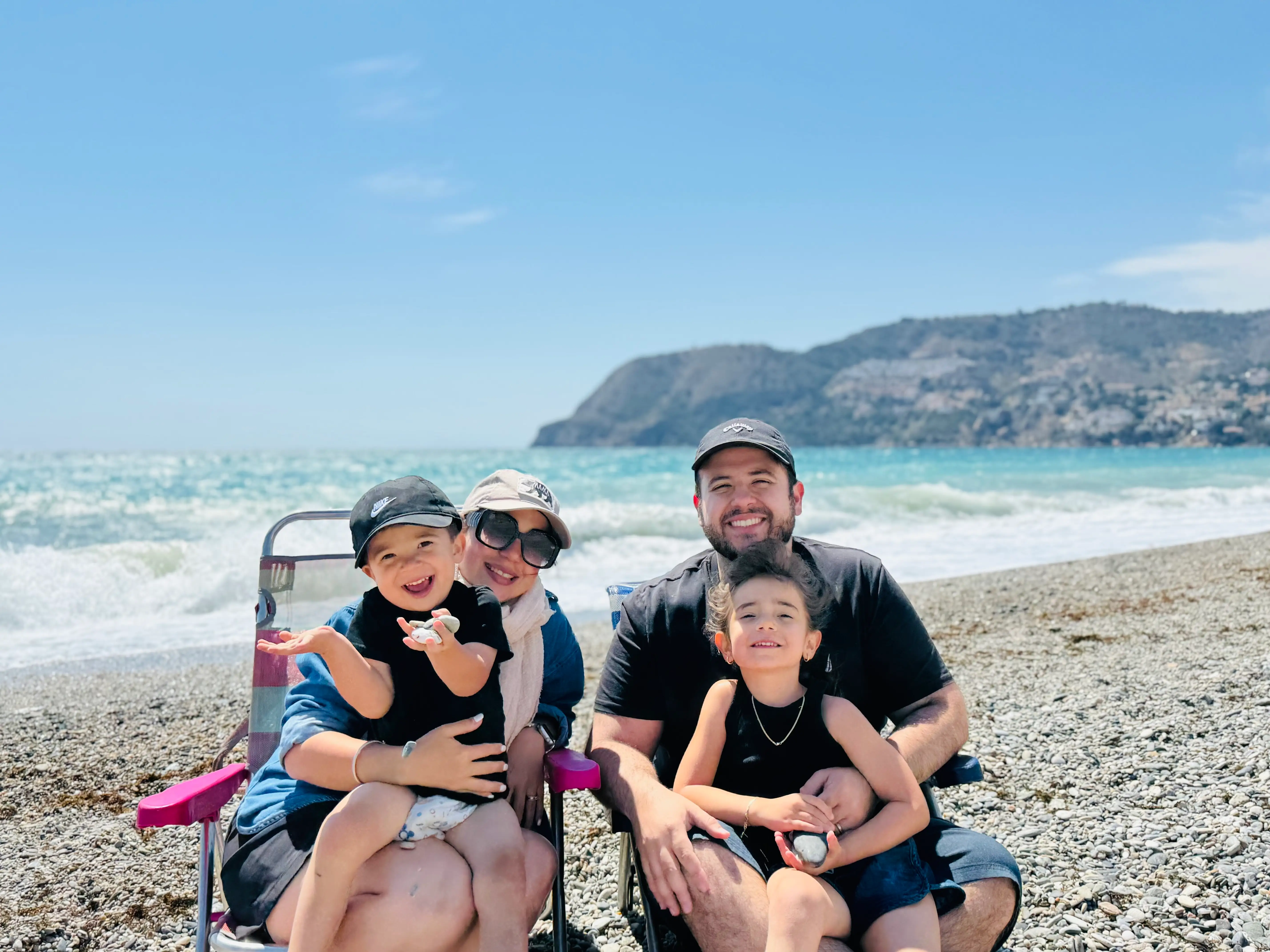 John Paul Hernandez and his family sitting on a spanish beach