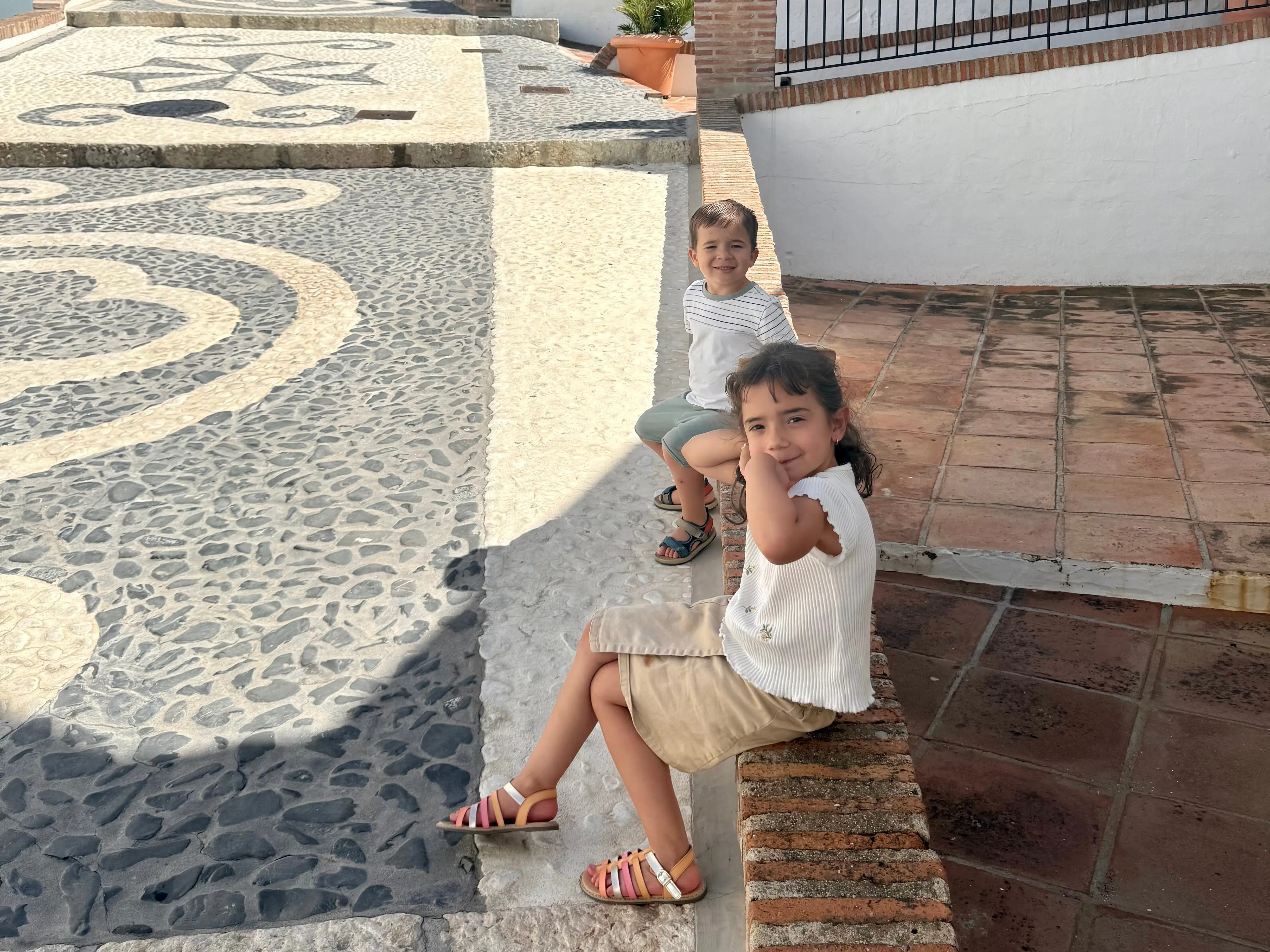 John Paul Hernandez's toddlers sitting on a wall in spain