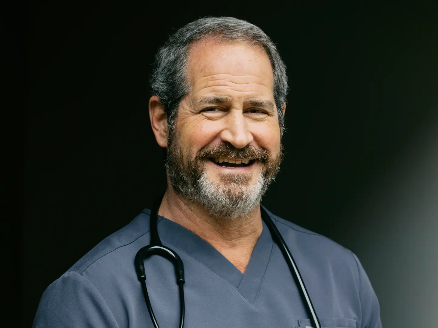 A doctor in blue scrubs and a stethoscope