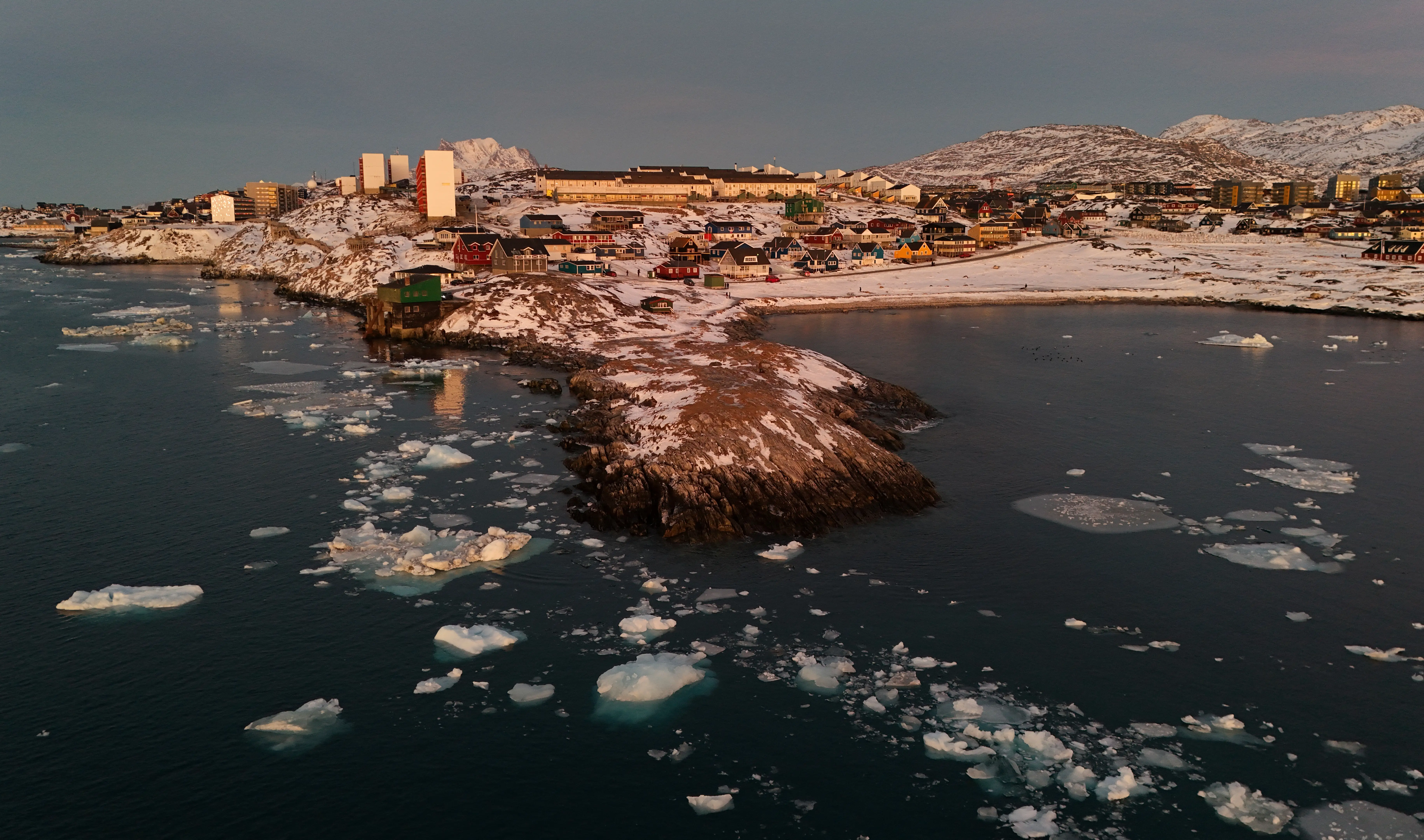 An aerial view shows ice blocks in the water near the coastline of the city of Nuuk, Greenland.