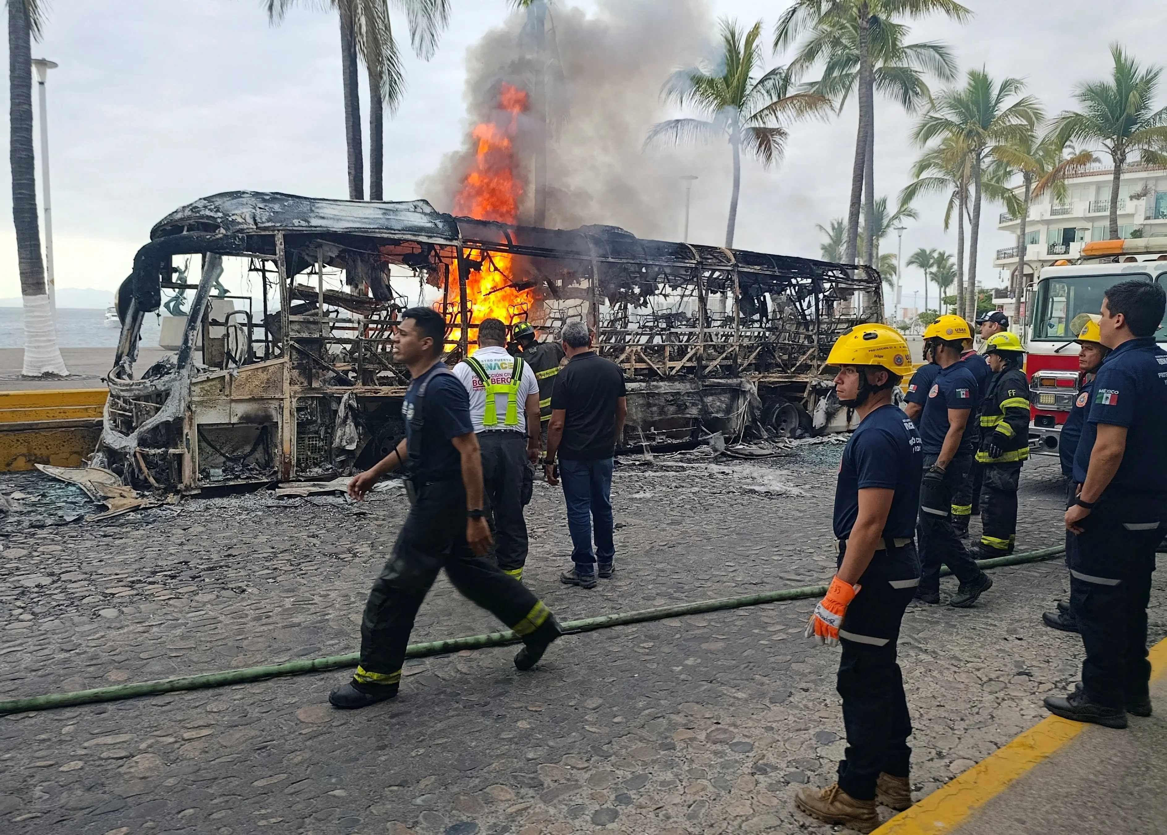 Firefighters by a burnt out bus in Puerto Vallarta, Mexico.
