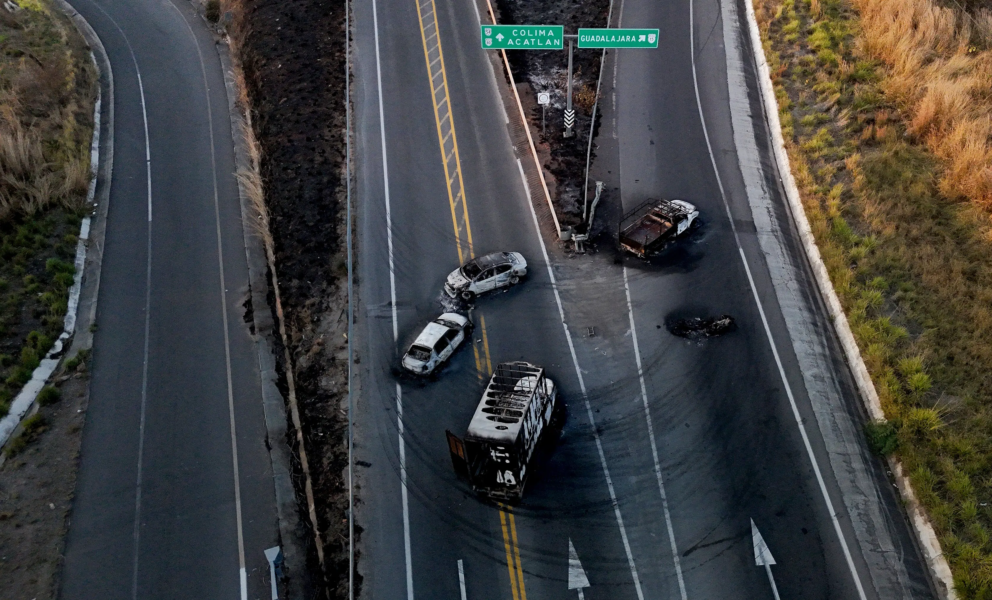 This aerial view shows burned cars and trucks on a highway.