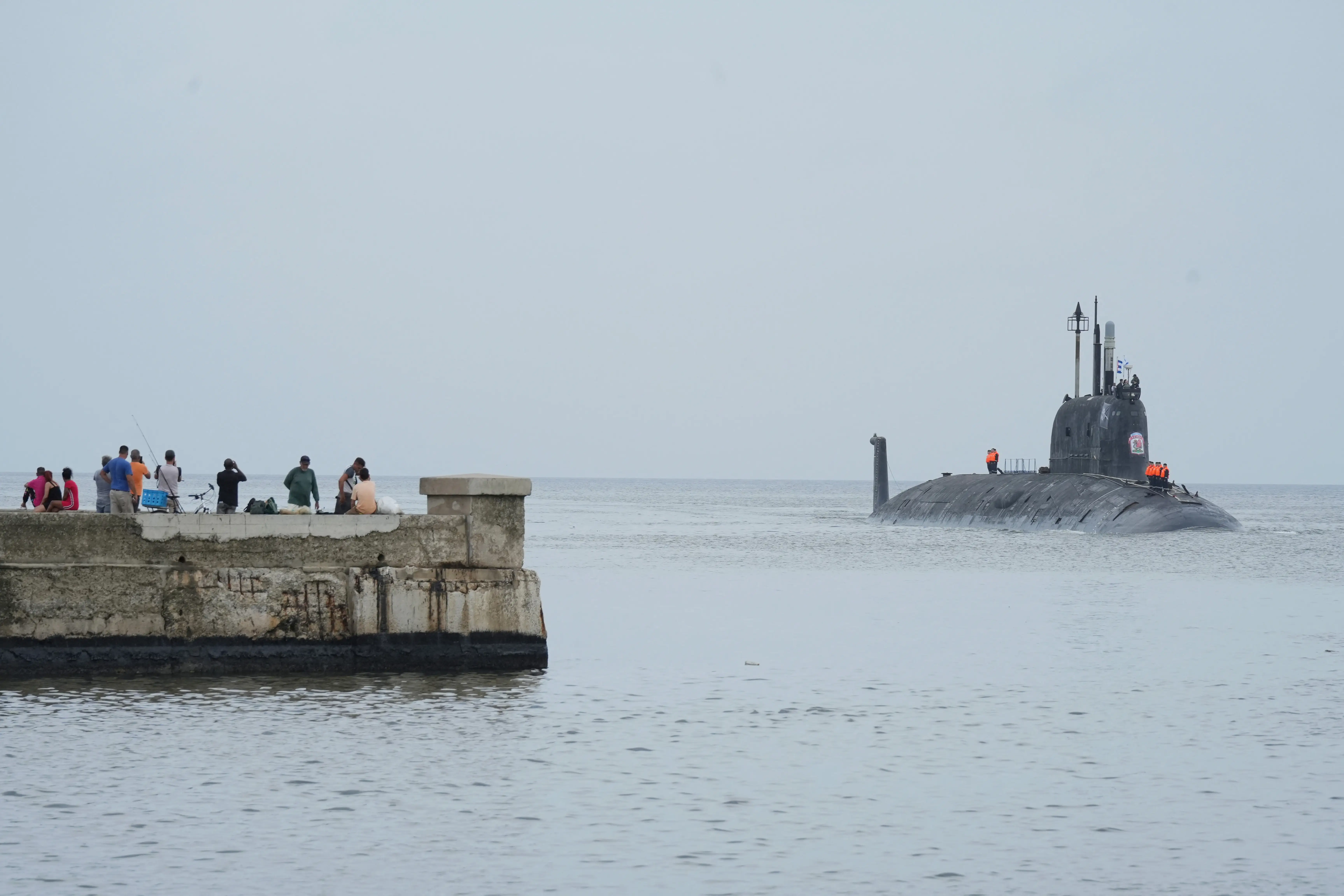 People watch the Russian nuclear-powered cruise missile submarine Kazan as it enters Havana Bay, Cuba, June 12, 2024.