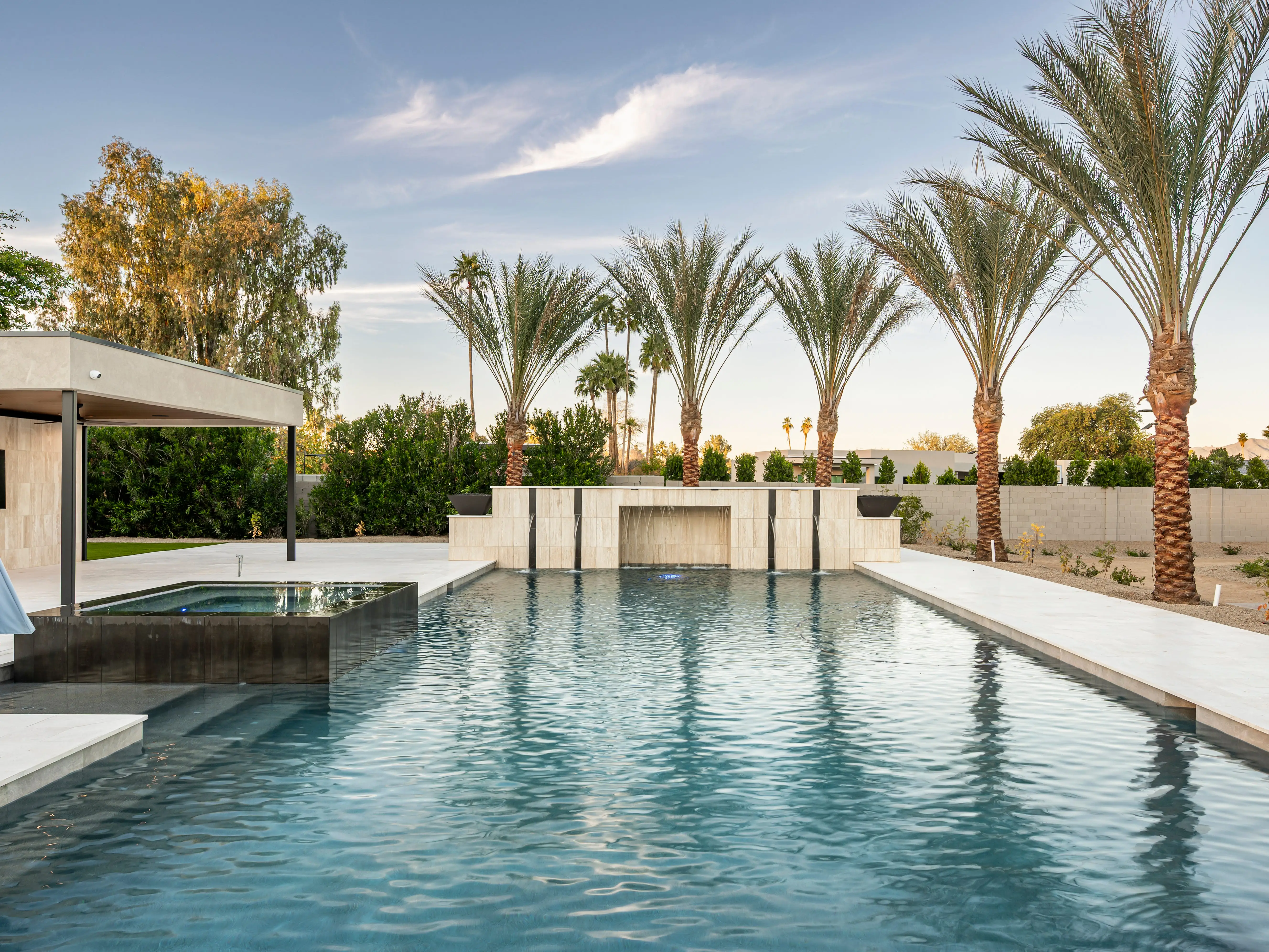 A pool in front of palm trees.