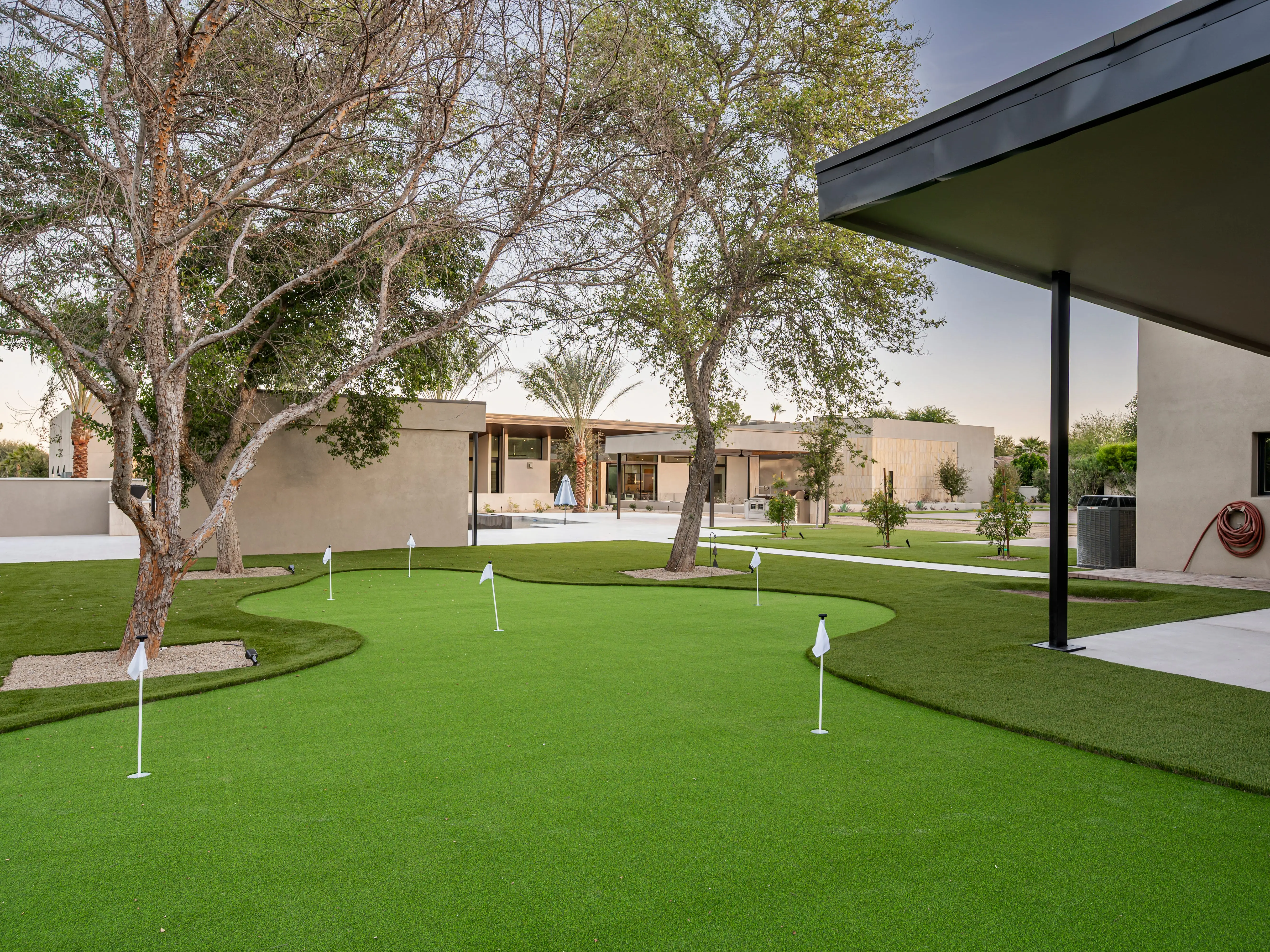 Holes with flags on a golf putting green.