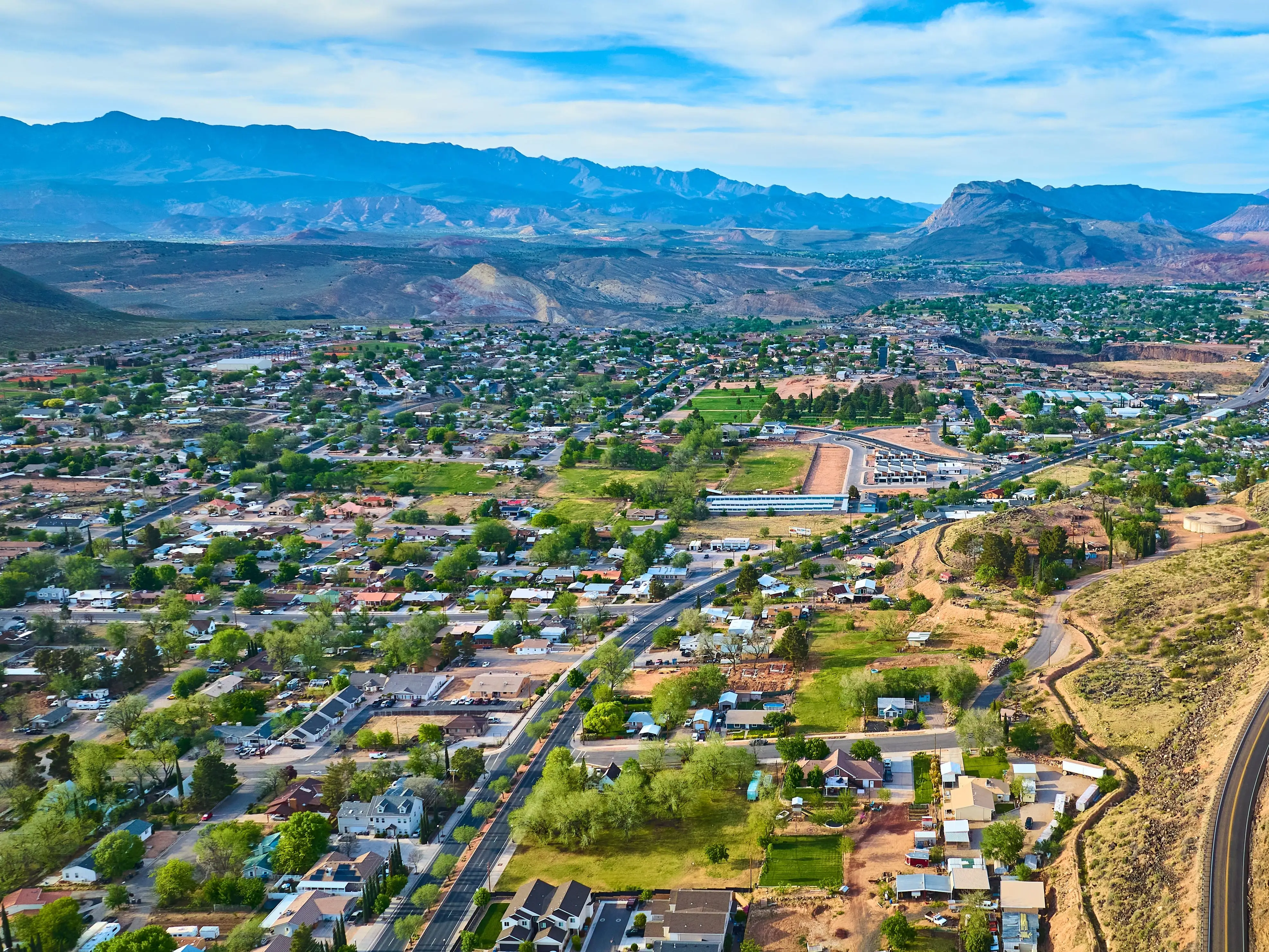 Aerial Suburban Neighborhoods and Desert Mountains in Hurricane Utah Fly Over