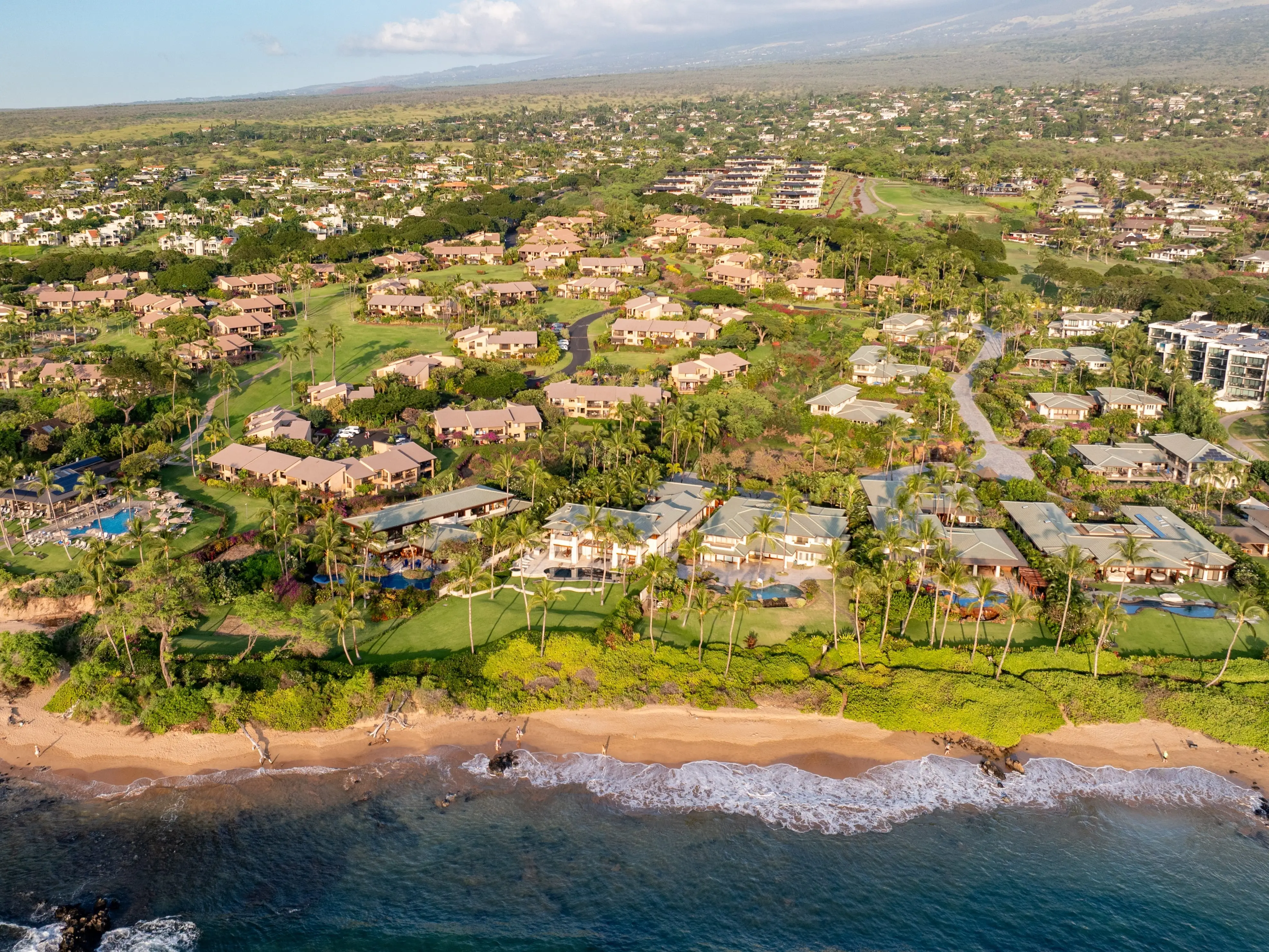 Panoramic Aerial view of condo resorts along Wailea beach path in Maui, Hawaii green landscape and coastal areas in Wailea-Makena during golden hour sunset