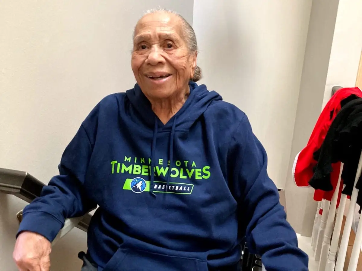 Woman smiling in chair lift wearing Minnesota sweatshirt