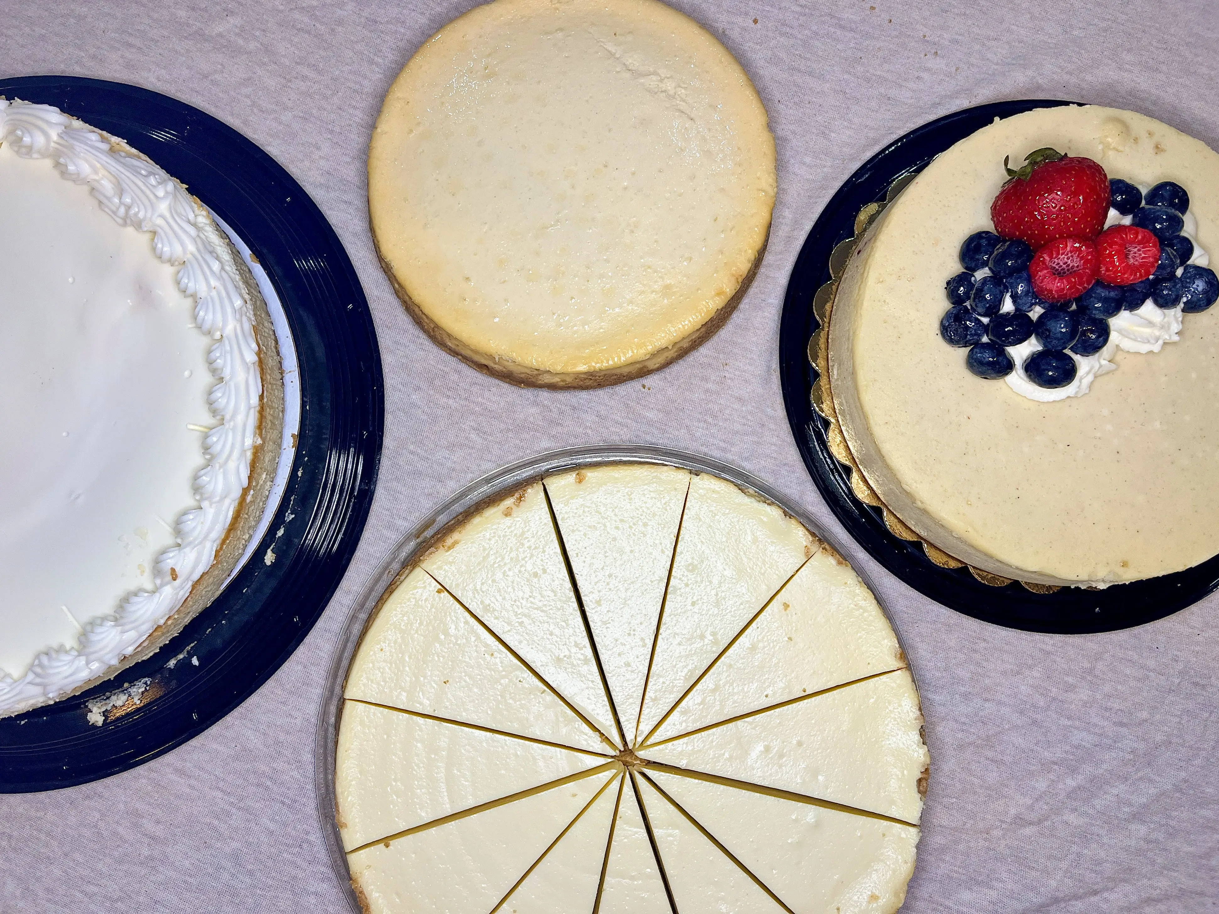 Four different cheesecakes on a table.