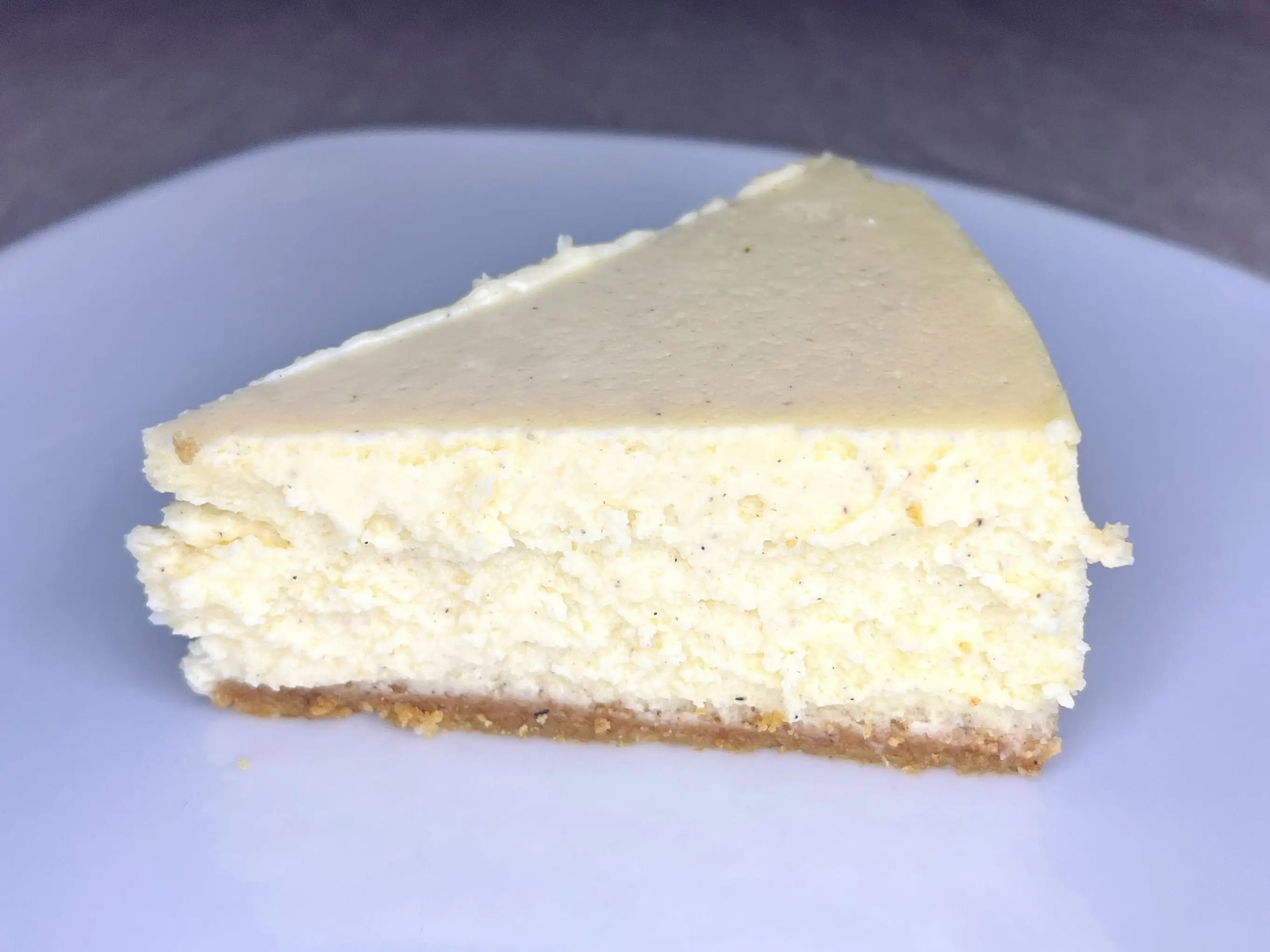 A slice of cheesecake on a white plate.