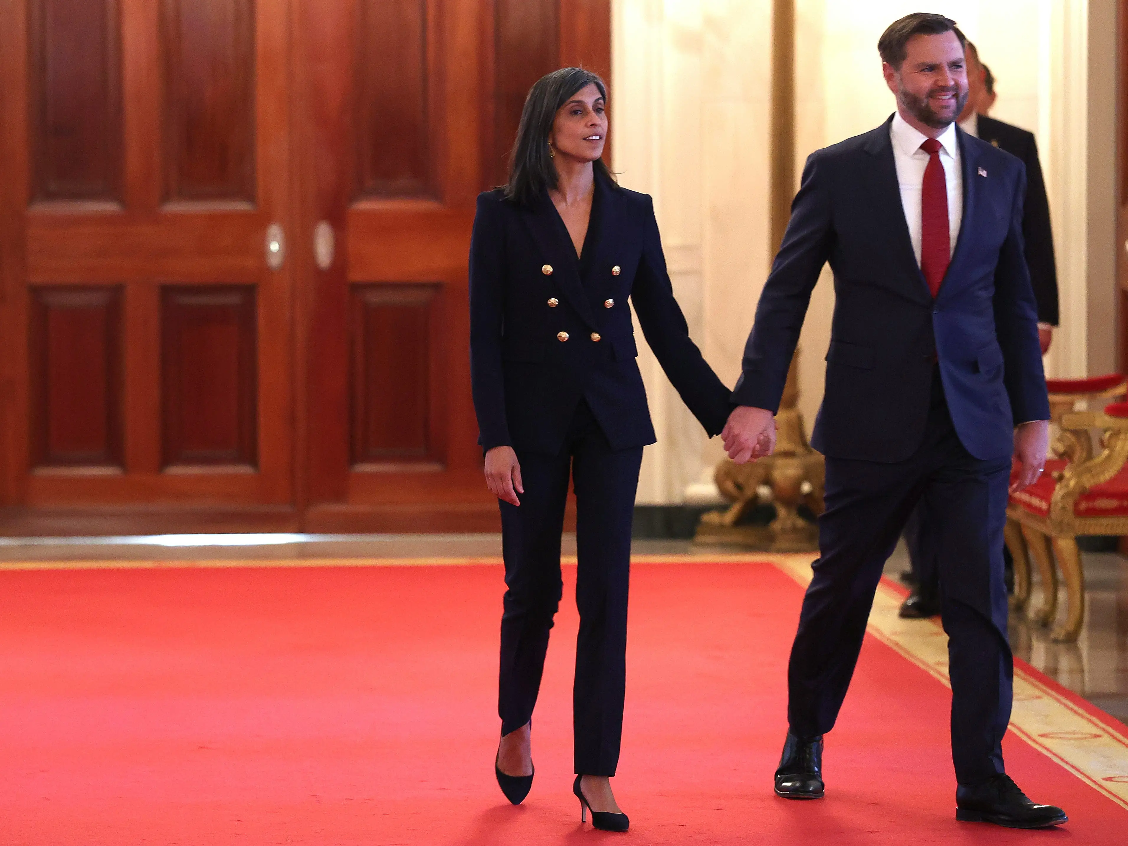 Usha Vance and JD Vance arrive at the East Room of the White House in November 2025.