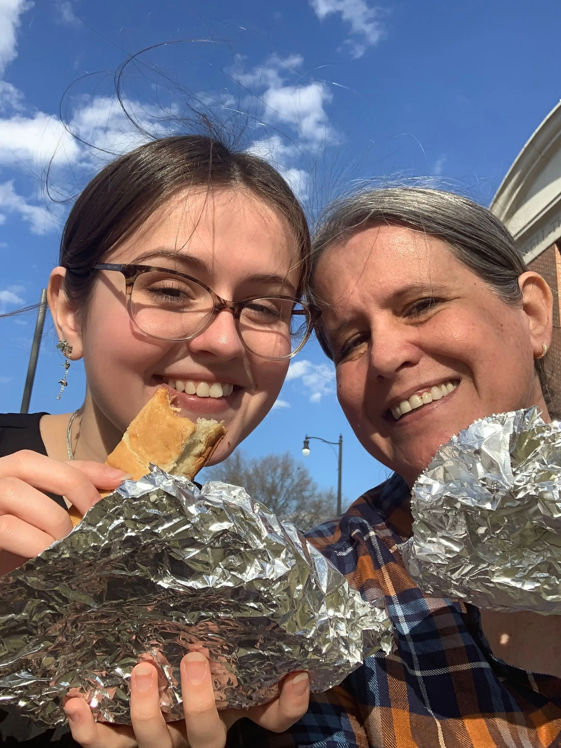 Woman and kid smiling with hot dogs