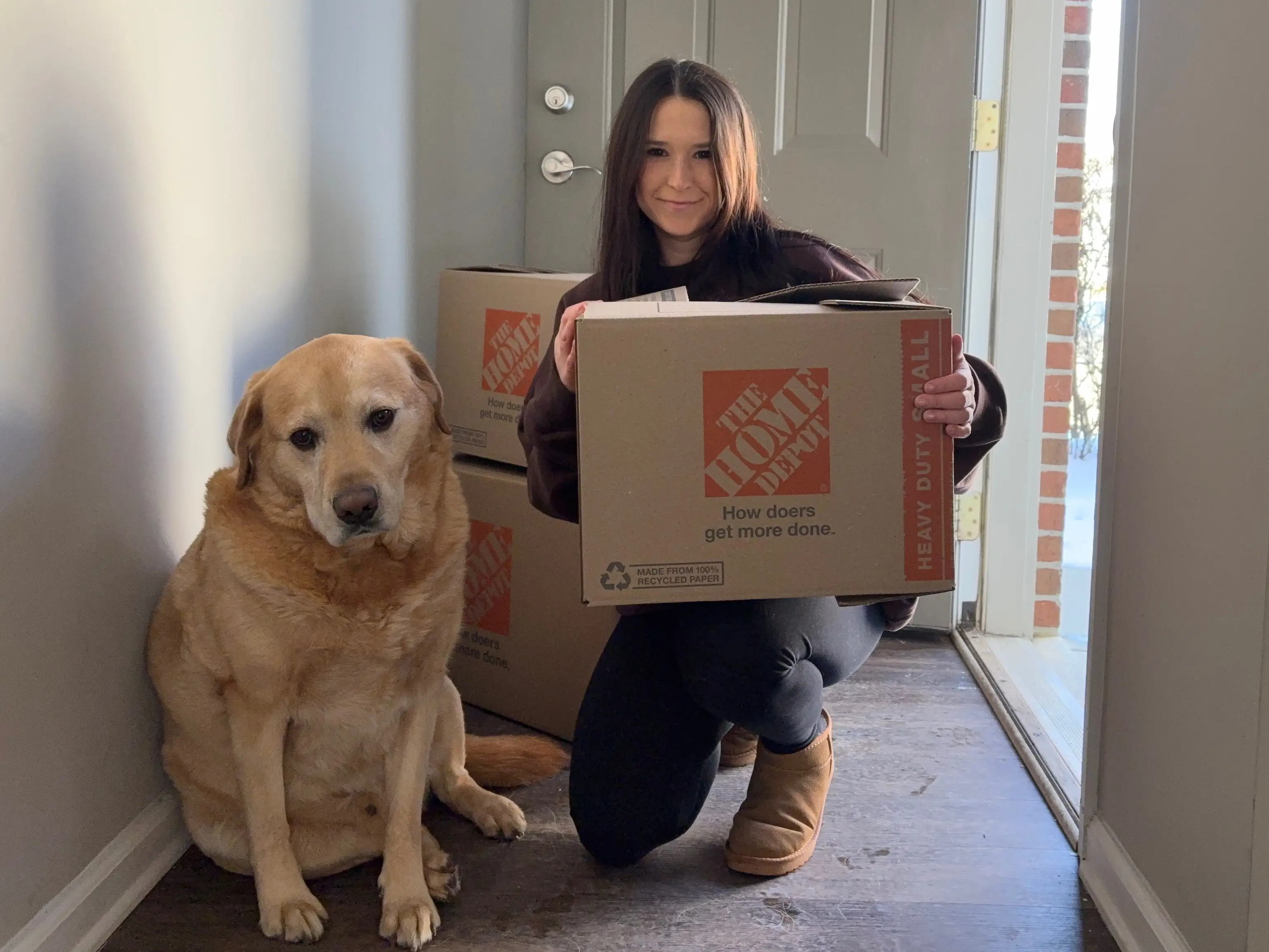 Erin Wetten and her dog with a moving box