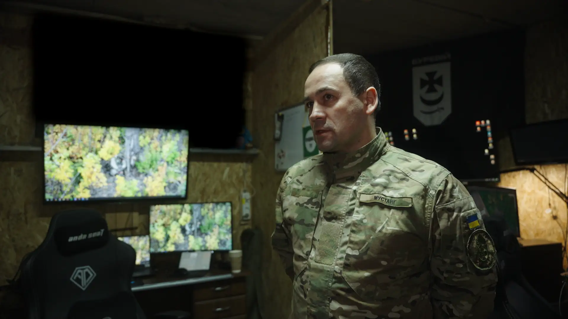 A man in military fatigues with a Ukrainian flag on his shoulder.