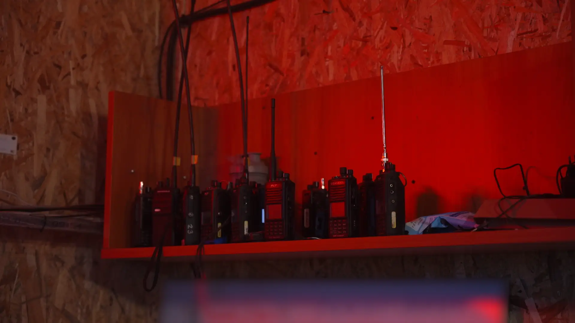 Walkie talkies under red light on a shelf