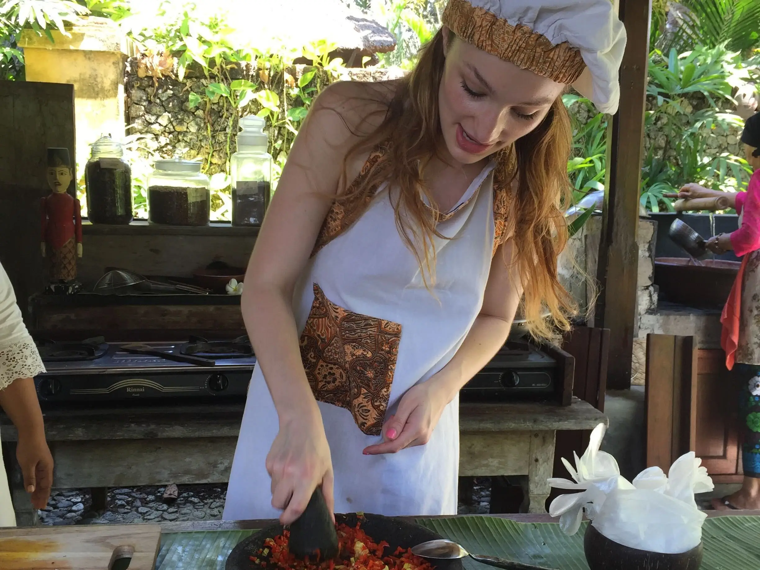 a woman taking a cooking class outdoors in Indonesia