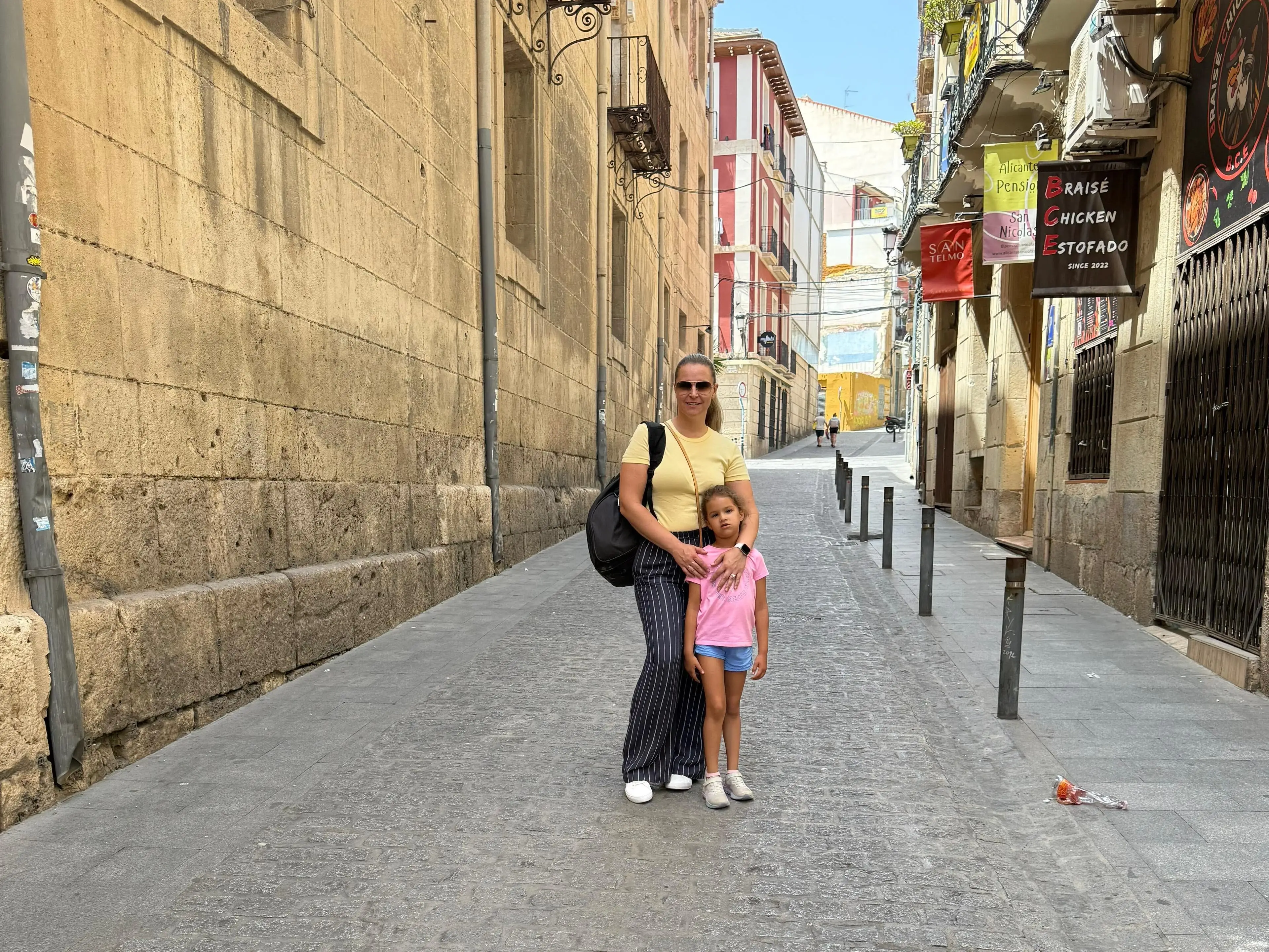 Izabela Oquendo and her young daughter stand in the middle of a Spanish street.