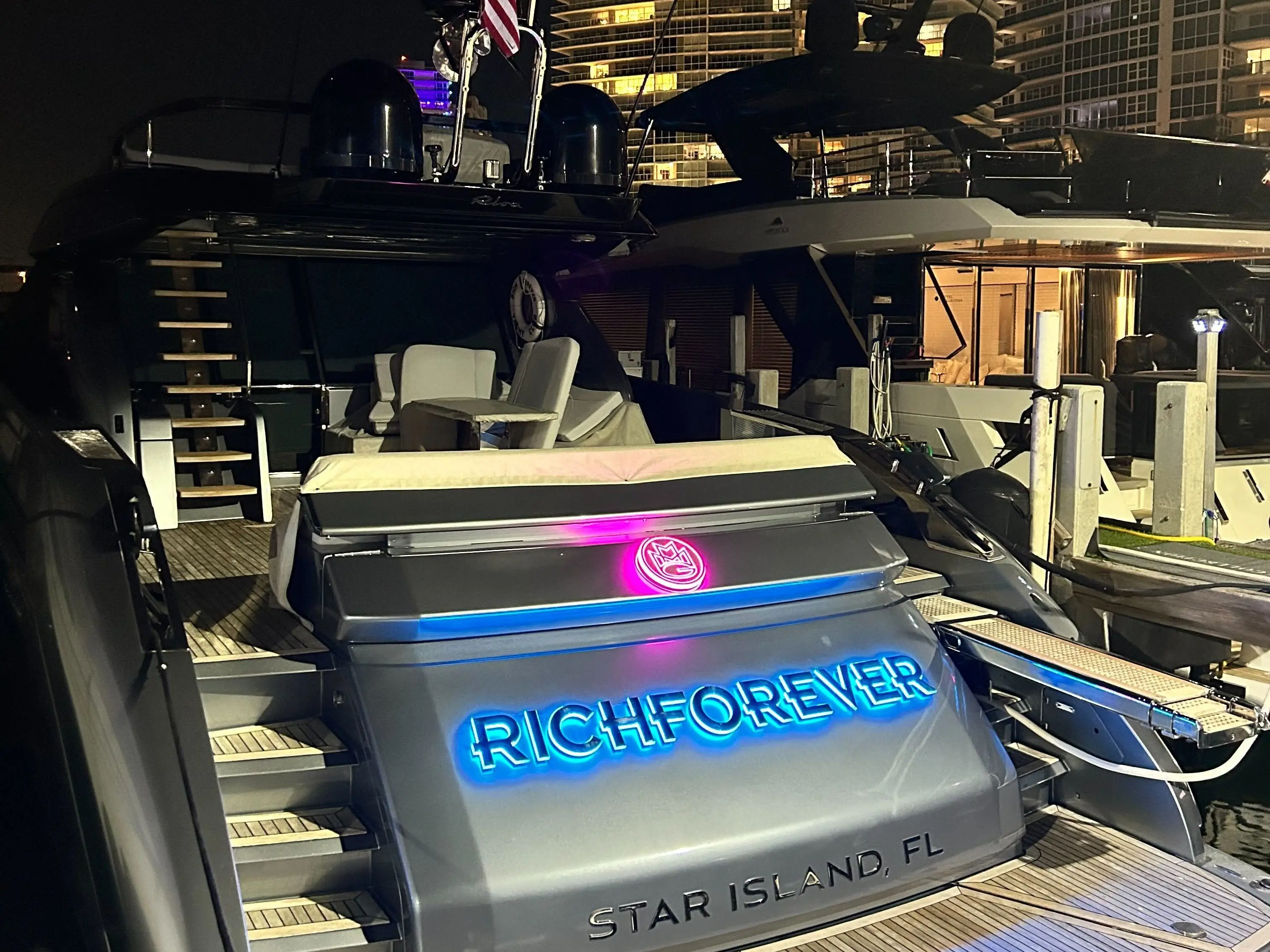 A yacht set against the backdrop of a condo building