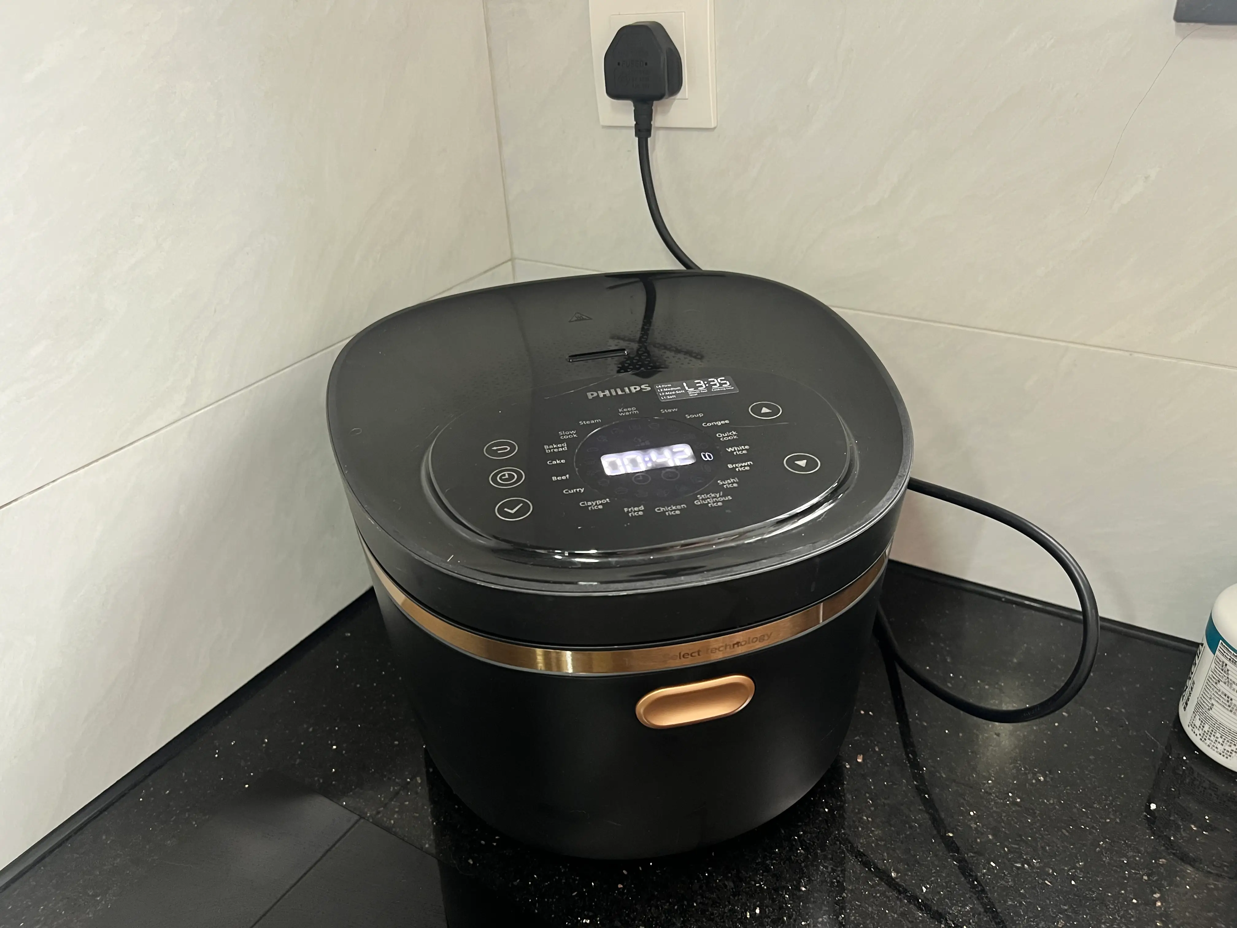 Black rice cooker plugged in.