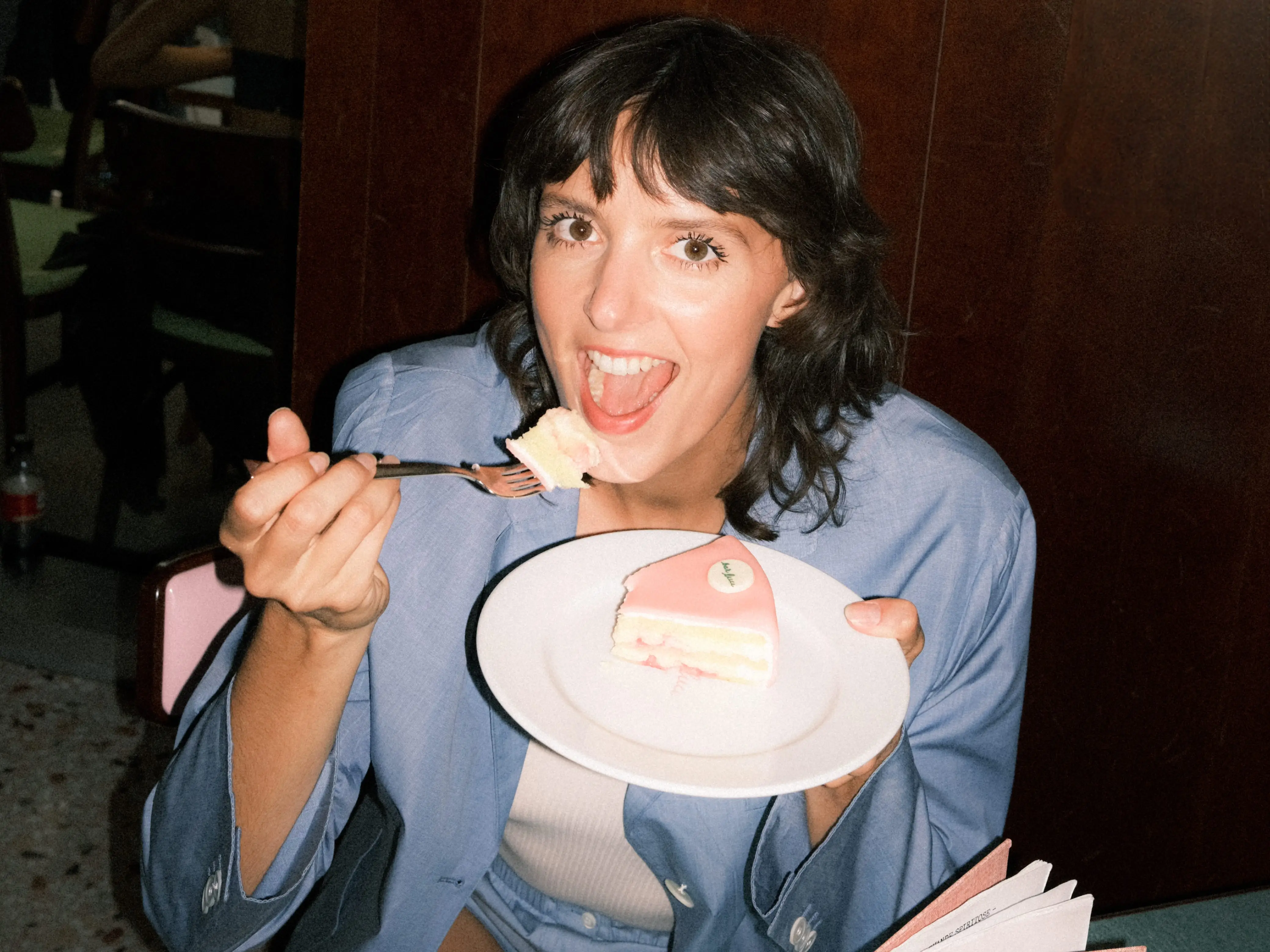 a woman eating a piece of cake at a restaurant