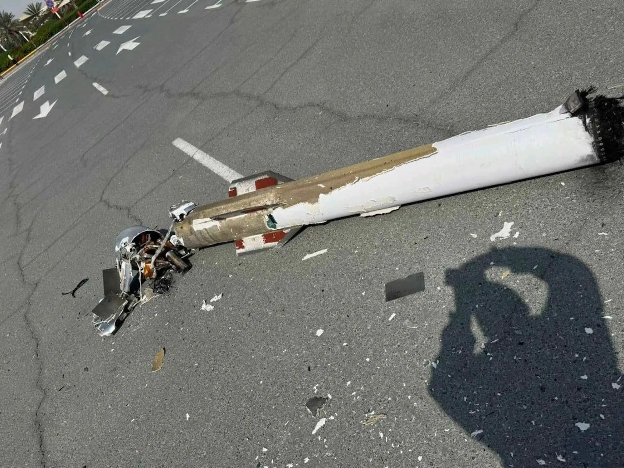 A white damaged missile on tarmac