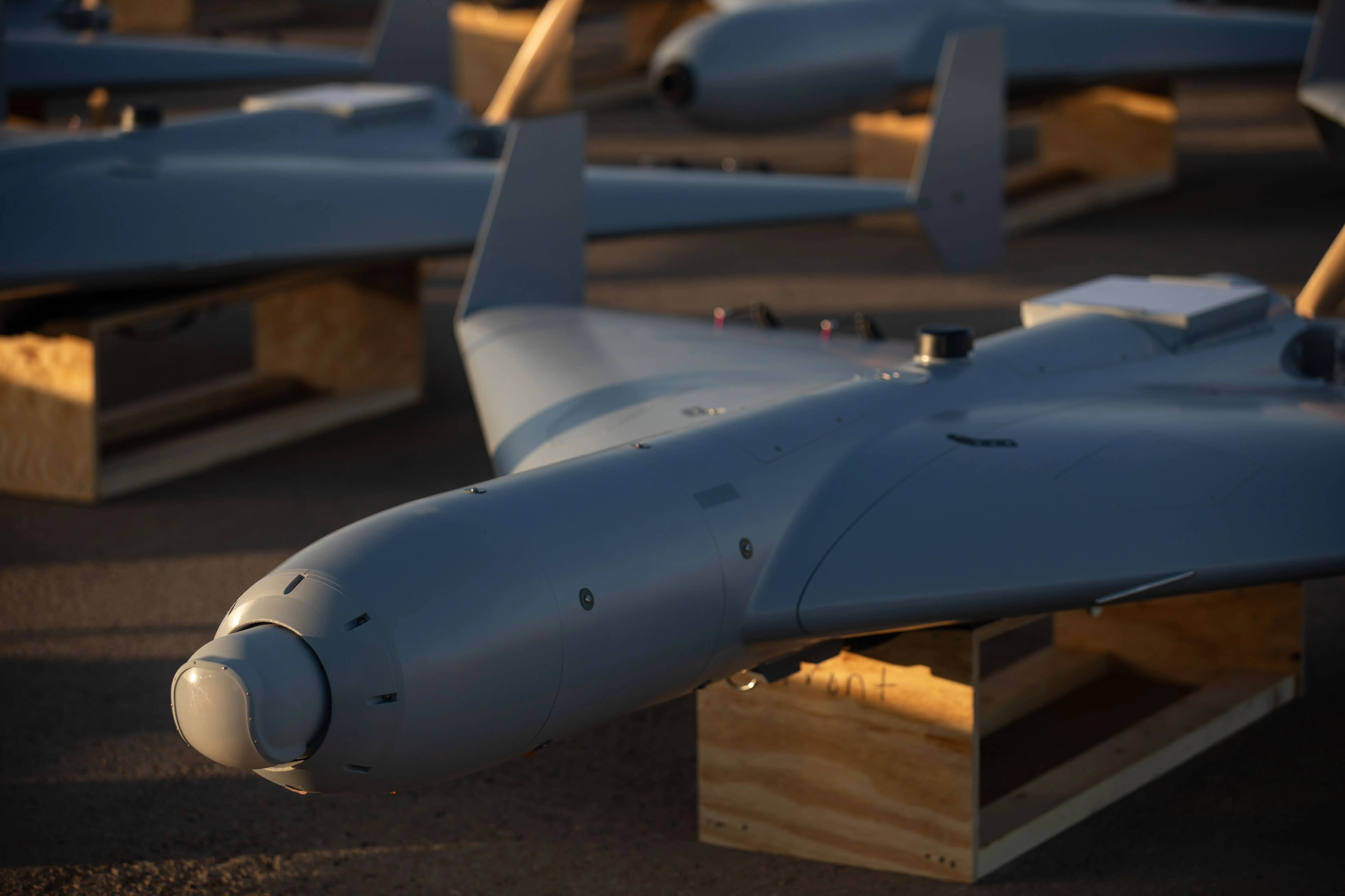 Cheap US military drones are positioned on a tarmac.