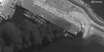 Satellite images show an Iranian warship burning pierside after US and Israeli strikes