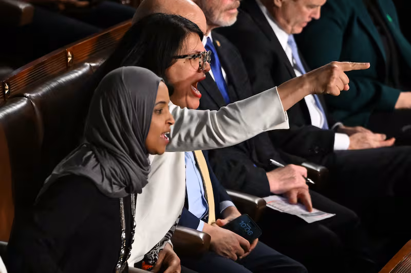 U.S. Representatives Ilhan Omar, Democrat from Minnesota, and Rashida Tlaib, Democrat from Michigan, shout as President Donald Trump delivers the State of the Union address in the House Chamber of the US Capitol in Washington, DC, on February 24, 2026.