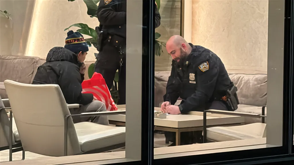 Police officers and Michael Tupas, son of carjacking victim Reynaldo Tupas, inside a building.