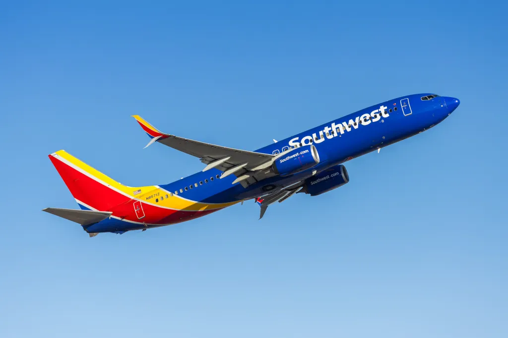 Southwest Airlines Boeing 737-800 airplane taking off against a clear blue sky.