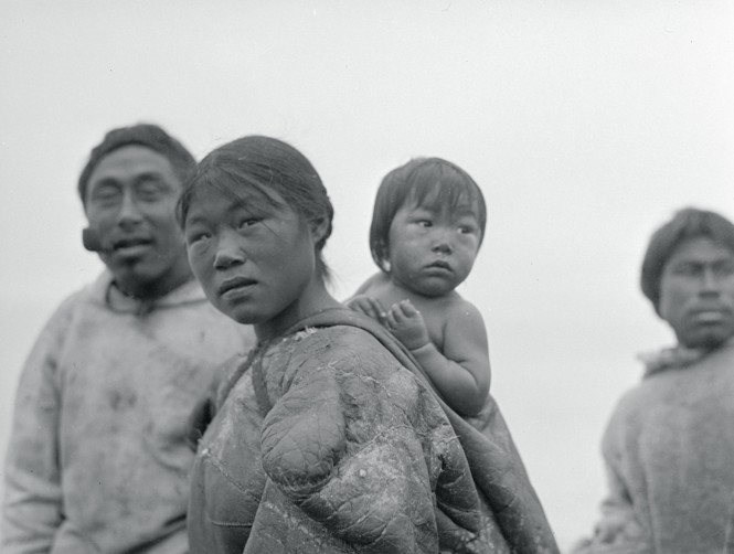 Portrait of Eskimo Family, a woman is seen in the foreground with her baby on her back