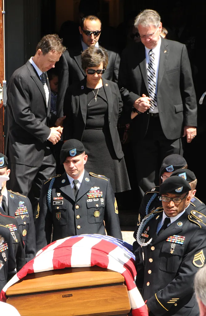 The parents of Sgt. Michael Ollis follow behind his casket at Our Lady Queen of Peace in