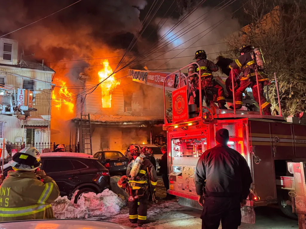 Firefighters battling a four-alarm fire at a residential building on 83-33 Dongan Avenue in Queens.