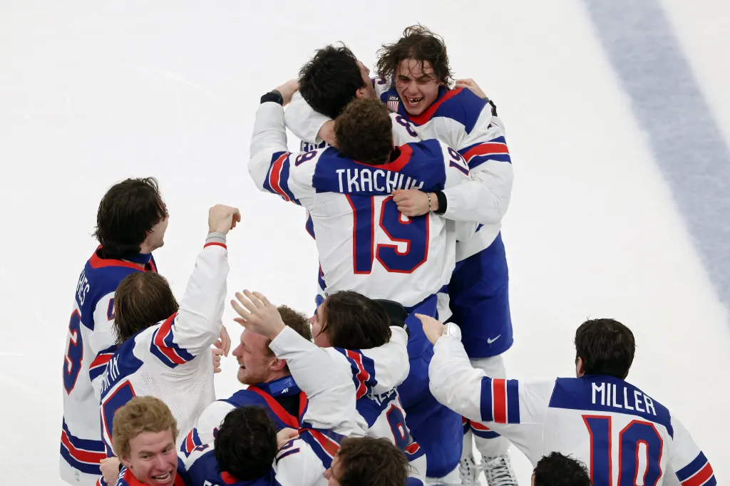 Team USA hockey players celebrate after scoring the game-winning goal.