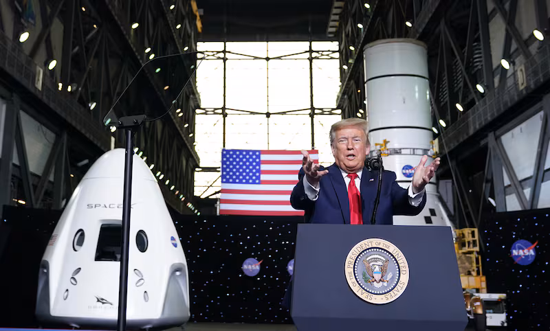 President Donald Trump speaks near a SpaceX Crew Dragon capsule at a press briefing after the launch of the SpaceX Falcon 9 rocket and Crew Dragon spacecraft on NASA's SpaceX Demo-2 mission to the International Space Station from NASA's Kennedy Space Center in Cape Canaveral, Florida on May 30, 2020.