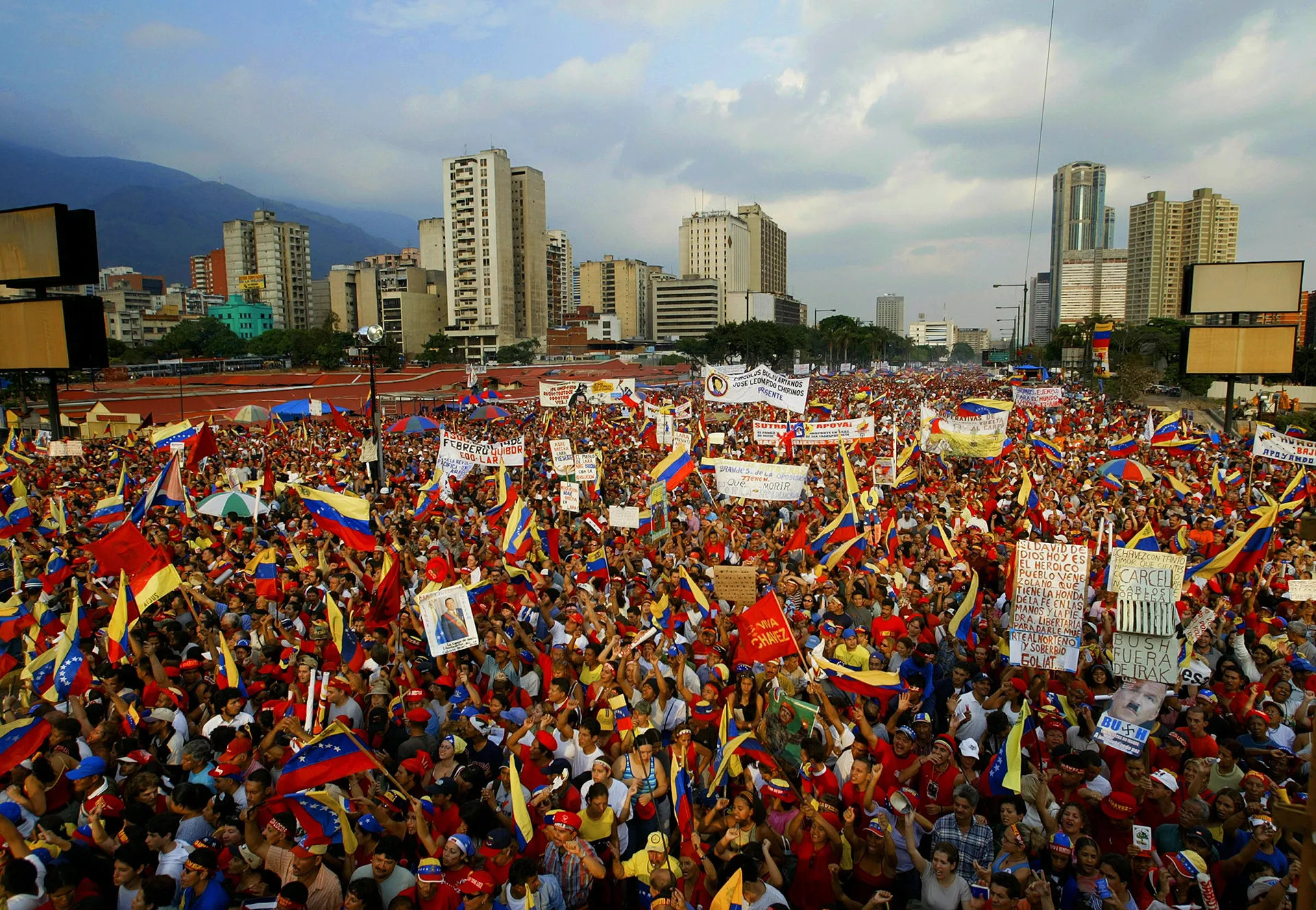 A massive crowd of people holding signs and Venezuelan flags outside A massive crowd of people holding signs and Venezuelan flags outside