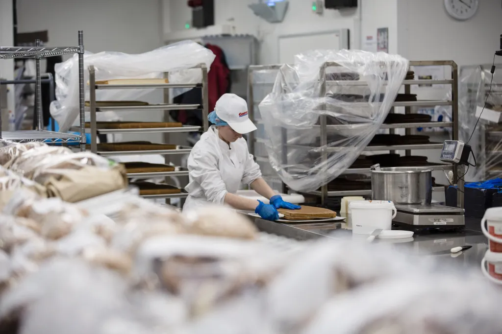An employee slices cake inside the bakery of a Costco Wholesale Corp. store