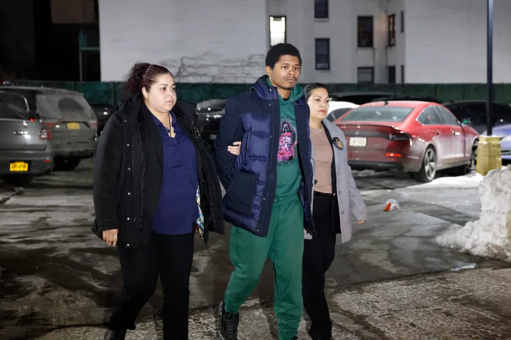 Dayvon Morrison being escorted by two women.
