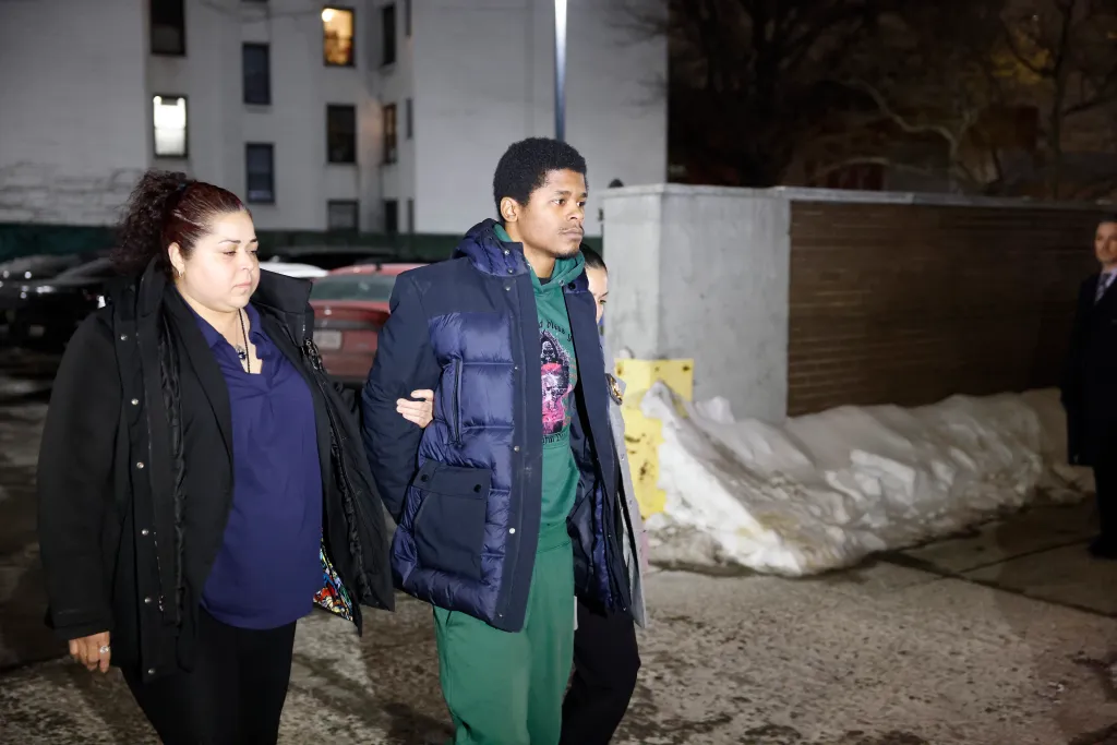 Dayvon Morrison being escorted by a woman and a police officer.