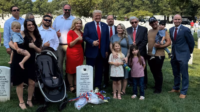 Donald Trump was photographed smiling and giving an awkward thumbs up Monday at the graves of fallen Marines in Arlington National Cemetery.