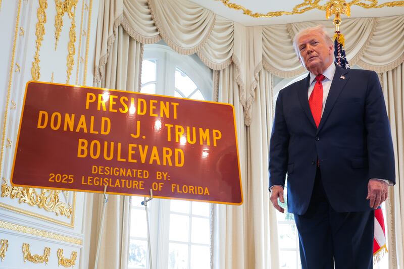 Trump with the "President Donald J. Trump Boulevard" sign during a Road Dedication Ceremony at Mar-a-Lago on January 16, 2026 in Palm Beach, Florida.