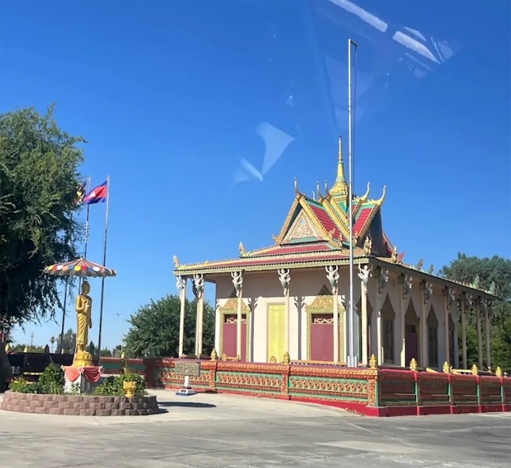 Fresno Cambodian Buddhist Society building with a gold Buddha statue and Cambodian flags.