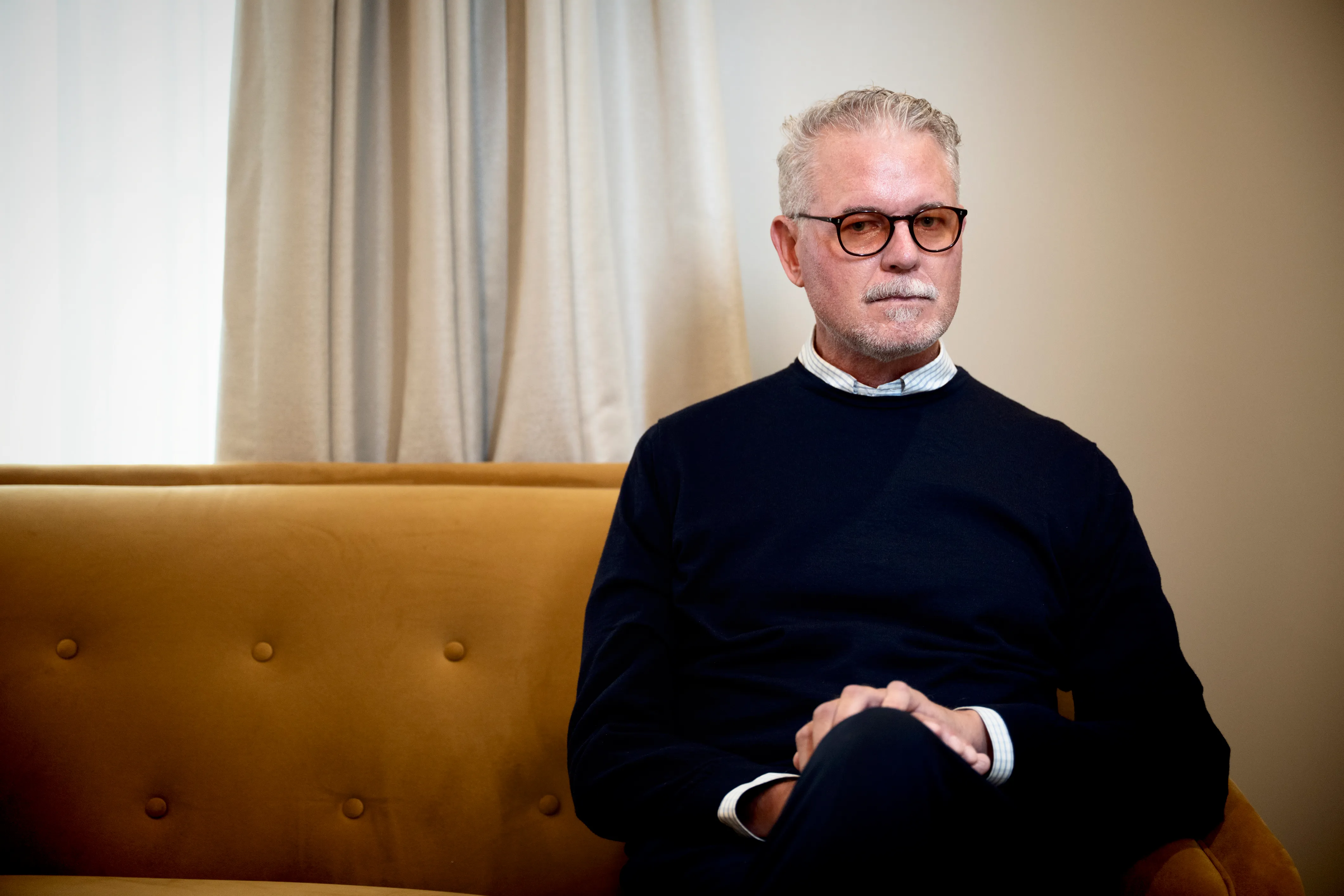 Actor Eric Dane sitting on a couch.