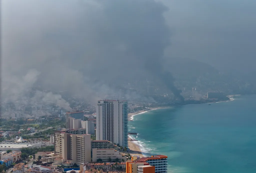 Aerial view of smoke plumes rising from Puerto Vallarta after cartel violence.