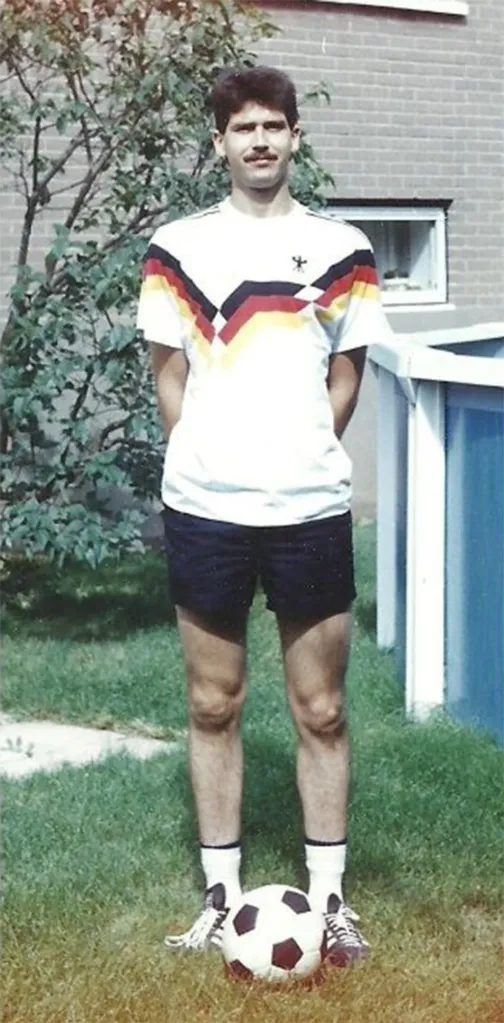 Manfred Sperling, also known as Amanda Joy Cooper, standing with a soccer ball.