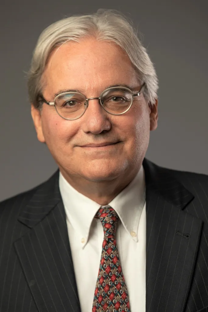 Attorney William Jacobson with gray hair, glasses, white shirt, and pinstripe suit.
